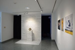 Installation view of three photographs and site-specific installation with writing on the wall and floor and white bust on pedestal.