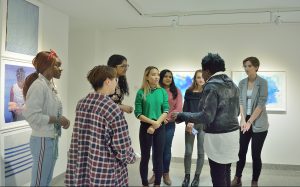 Women artist speaking with students.