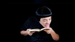Woman licking a book.