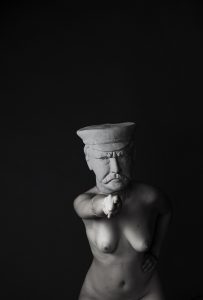 White figure with head of a sculpture on black background.