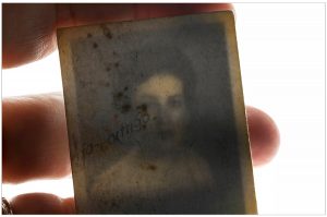 Image of hand holding transparent photograph.