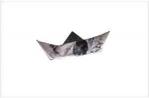 Black and white origami boat with child's face.