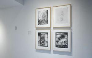 Installation view of four black and white photographs with face of woman