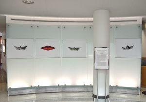 Installation view of four photographs of boats against glass.